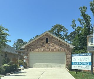 Street view Charming brick home with a spacious garage in Woodland Lakes by Cyrene Homes (Huffman, TX).