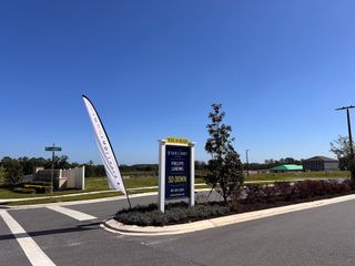 Welcome to Phillips Landing by Starlight Homes in Groveland, FL, featuring inviting landscaping and clear blue skies.