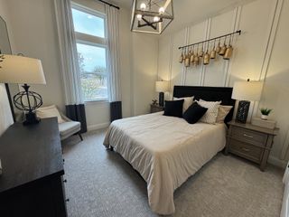 A warm and inviting bedroom with wood flooring, accent walls, and cozy textures in Veramendi by Brightland Homes (New Braunfels, TX).