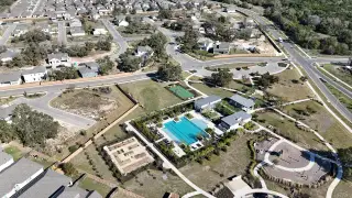 Street view A vibrant community with lush amenities, pool, and sports courts in Anthem by Newmark Homes, Kyle, TX.