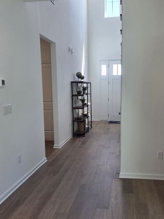 Model Home A sleek hallway with wooden floors, high ceilings, and modern decor, creating an inviting and airy entryway.