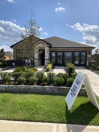 Street view A charming brick home with lush landscaping in Magnolia Place by Meritage Homes, located in Magnolia, TX.