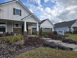 Charming modern farmhouse with stone accents and lush landscaping in Trailmark Phase 10 by Drees Custom Homes (St. Augustine, FL).