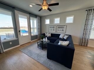 Model Home A cozy living room with a navy sectional sofa, accent pillows, and large windows for abundant natural light.