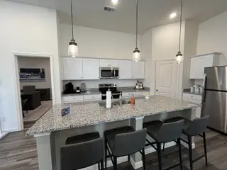 A modern kitchen with granite countertops, stainless steel appliances, and pendant lighting, perfect for entertaining.