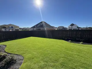 Model Home A lush, green backyard fenced for privacy in Santa Rita Ranch by GFO Home (Liberty Hill, TX).