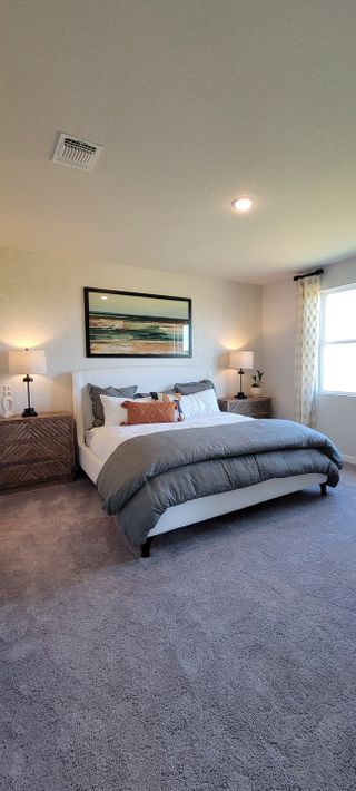 A cozy bedroom retreat with a plush bed, textured nightstands, and warm lighting for ultimate relaxation.