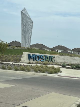 A modern entrance with a striking sculpture welcomes you to Mosaic 50' by Perry Homes in Celina, TX.