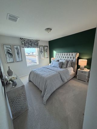 A cozy bedroom with a tufted headboard, dark green accent wall, and elegant decor, creating a serene atmosphere.