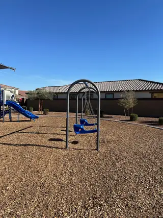 Community Amenities A vibrant playground with swings and slides in Ventana de Estrellas Enclaves by KB Home, Goodyear, AZ.