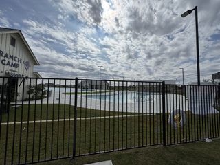 Community Amenities A modern community pool with sleek fencing and clubhouse in Santa Rita Ranch – Augustine by Sitterle Homes (Liberty Hill, TX).