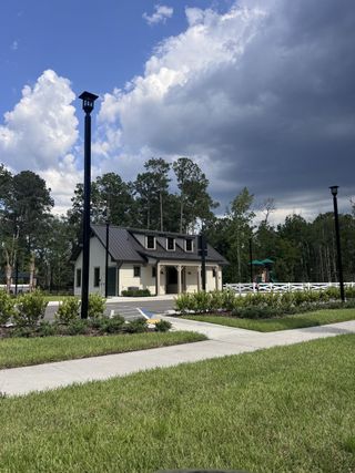 A quaint community building with a dark roof and lush landscaping in Jennings Farm by LGI Homes (Middleburg, FL).