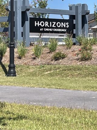 A welcoming entrance sign for Horizons at Carnes Crossroads by Lennar, set amidst landscaped greenery in Summerville, SC.