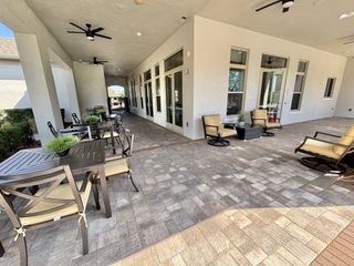 Community Amenities A spacious covered patio with ceiling fans and cozy seating for relaxation in Kindred by D.R. Horton (Kissimmee, FL).