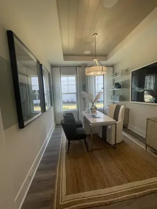 A modern home office with elegant decor, featuring a sleek desk, plush seating, and soft lighting.