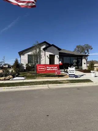 A modern white brick home with a landscaped front in Bar W Ranch by D.R. Horton (Leander, TX).