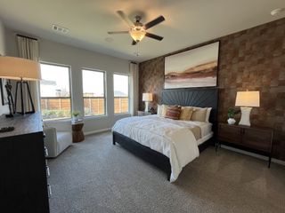A cozy bedroom with a built-in desk, warm decor, and an inviting atmosphere in Solterra by Chesmar Homes (Mesquite, TX).