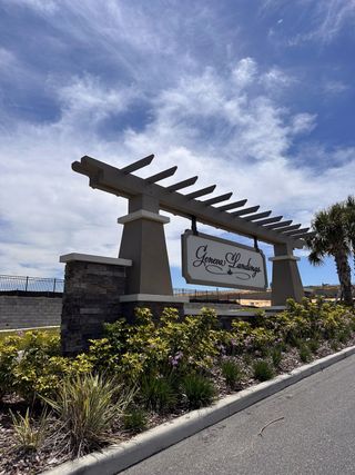 Street view A welcoming stone entryway with a pergola sign at Geneva Landings by Highland Homes of Florida in Davenport, FL.