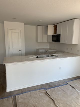 Model Home A modern kitchen with sleek white cabinetry, a clean countertop, and a functional island in progress.