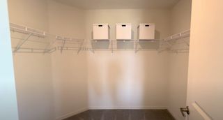 A spacious walk-in closet with organized white shelving and storage boxes for efficient use of space.