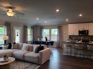 A cozy open-plan living area with a modern kitchen, stylish dining space, and inviting neutral-toned seating.