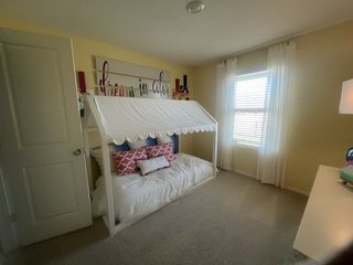 Model Home A charming children’s bedroom with a whimsical house-frame bed and colorful wall art.