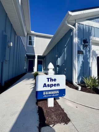 Street view Charming blue home in Corsair by D.R. Horton, featuring a modern facade and pathway in Middleburg, FL.
