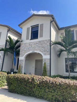 A modern home with stone accents and palm landscaping in Siena Reserve: Del Mesa Collection by Lennar (Miami, FL).