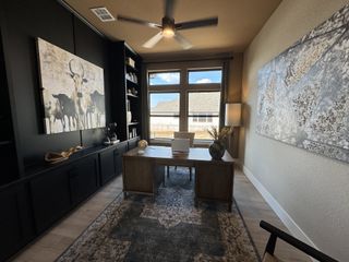 Model Home A sophisticated home office with sleek black cabinetry, large art pieces, and a windowed wall for natural light.