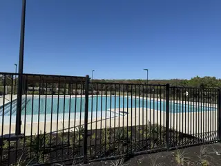 Community Amenities A community pool with a sleek fence in Parkside on the River by Coventry Homes, Georgetown, TX.