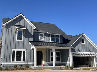 Street view A modern gray home with a spacious garage and porch in Norwood Oaks by David Weekley Homes (Mount Pleasant, SC).