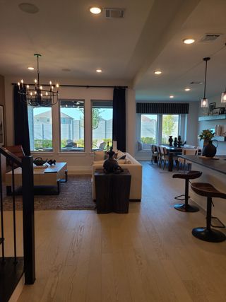 A stylish living area with large windows, sleek light fixtures, and an open dining space, creating a cozy and modern ambiance.