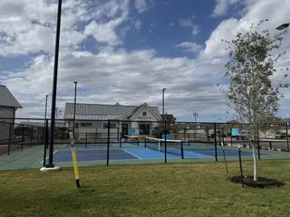 Community Amenities A modern recreational area with tennis courts in Santa Rita Ranch: 90ft. lots by Highland Homes (Liberty Hill, TX).