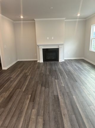 A bright living room with elegant wood flooring, a cozy fireplace, and neutral tones creating a warm and inviting atmosphere.