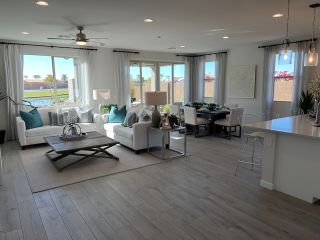 A bright, open living and dining area with large windows, modern furniture, and elegant decor.