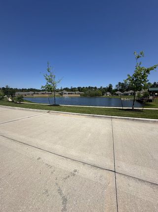 A serene lakeside view with lush greenery in Wedgewood Forest by LGI Homes, Conroe, TX.