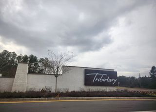 Street view A modern entrance sign stands grandly at Tributary: Tributary Classic Collection by Lennar in Yulee, FL.
