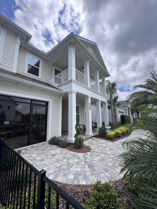 Street view A beautiful two-story home with a spacious porch and landscaped entry in Reflections at Seabrook by ICI Homes (Nocatee, FL).
