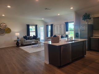 An open-concept living area with wood floors, modern kitchen island, and cozy seating, perfect for entertaining.