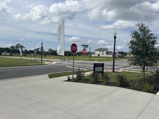 A charming streetscape with lush greenery and modern signage in Trailside by Ashton Woods (Mount Dora, FL).