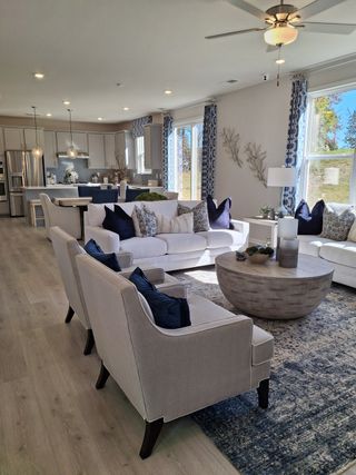 A spacious, elegant living area with modern decor, open kitchen, and ample natural light.