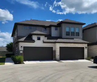 Street view Spacious two-story home with a modern exterior in Sonoma Heights by Coventry Homes (Round Rock, TX).