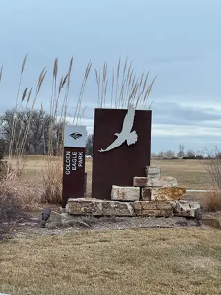 A scenic park entrance with a bird sculpture in Villages at Prairie Center by Richmond American Homes (Brighton, CO).