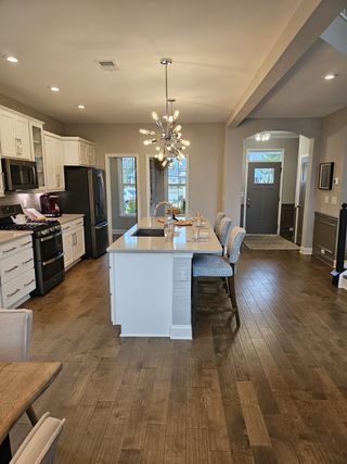 A modern kitchen with a spacious island, pendant lighting, and white cabinetry, seamlessly connecting to the dining area.