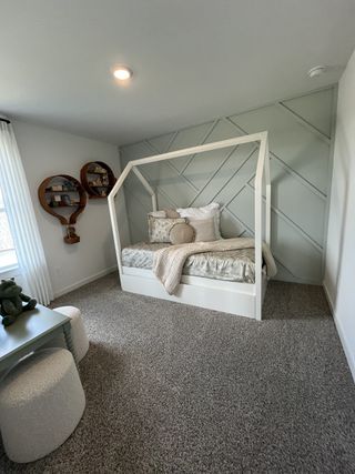 Model Home A cozy children's room with a charming daybed, geometric accent wall, and playful decor elements.
