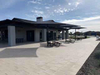 Community Amenities A sleek community center with shaded picnic tables in Bella Vista Trails Reserve Series by Meritage Homes (San Tan Valley, AZ).