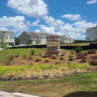 Street view Charming homes in Sandtown Falls by Rockhaven Homes, Atlanta, GA, surrounded by lush landscaping and clear blue skies.