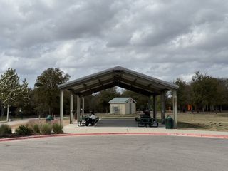 A community pavilion with picnic tables in Village at Manor Commons by Landsea Homes (Manor, TX).