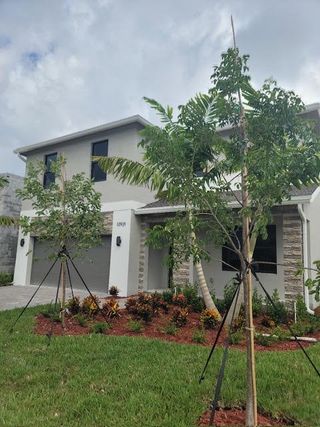 A modern two-story home with lush landscaping in Rosemont by D.R. Horton (Miami, FL).