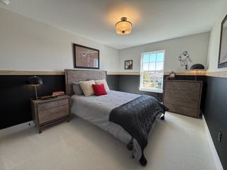 A cozy bedroom with textured wood furniture, a modern light fixture, and sporty wall art creating a stylish retreat.